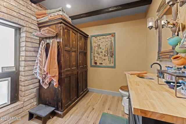 office area featuring beam ceiling, light hardwood / wood-style floors, and sink