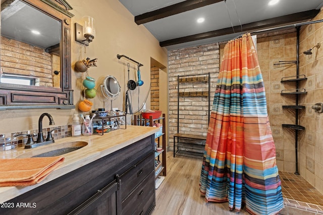 bathroom featuring hardwood / wood-style floors, a shower with shower curtain, beamed ceiling, and vanity