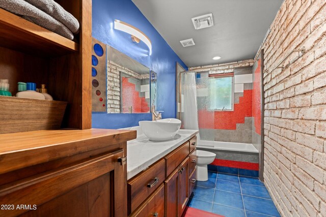 full bathroom with tile patterned floors, shower / bath combo, toilet, brick wall, and vanity