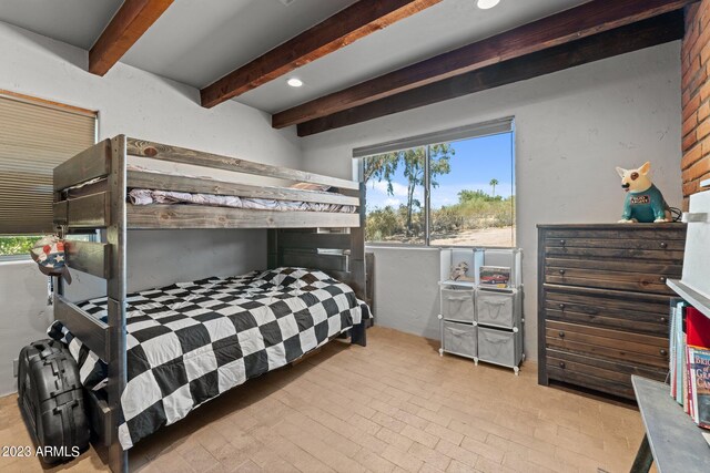 bedroom featuring beam ceiling and multiple windows