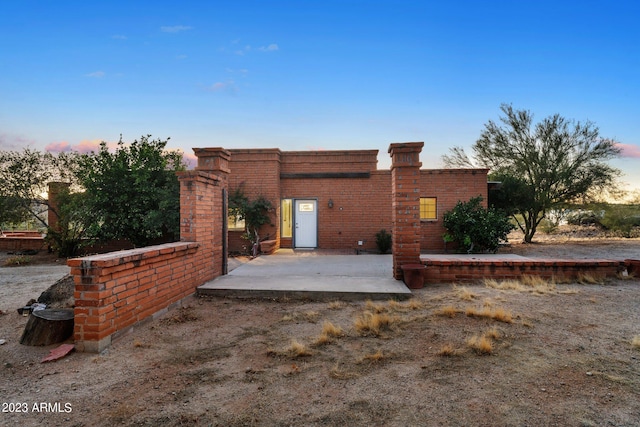 back house at dusk with a patio