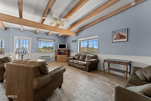 living room featuring ceiling fan, light hardwood / wood-style floors, lofted ceiling with beams, and a healthy amount of sunlight