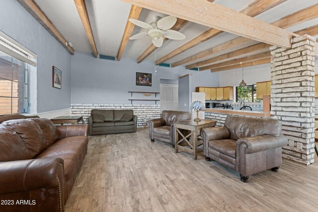 living room with light hardwood / wood-style floors, beam ceiling, and ceiling fan