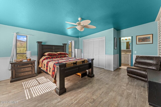 bedroom with ensuite bath, lofted ceiling, ceiling fan, and light hardwood / wood-style floors