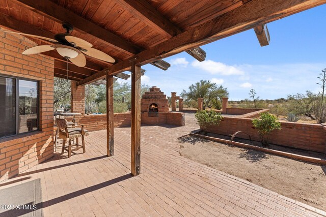 view of patio with ceiling fan and exterior fireplace