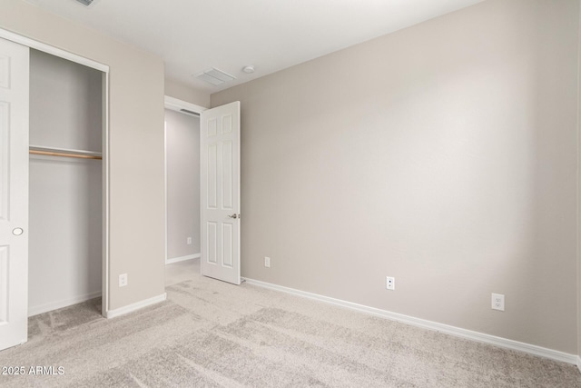 unfurnished bedroom with a closet and light carpet