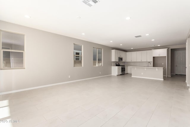 unfurnished living room with sink and light tile patterned flooring