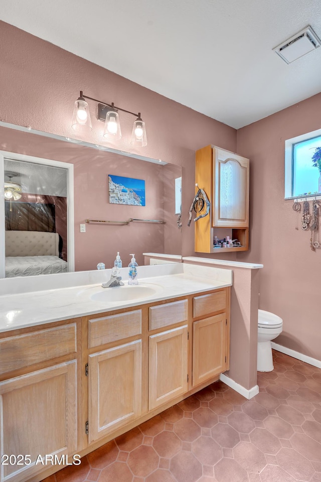 bathroom featuring vanity, tile patterned floors, and toilet