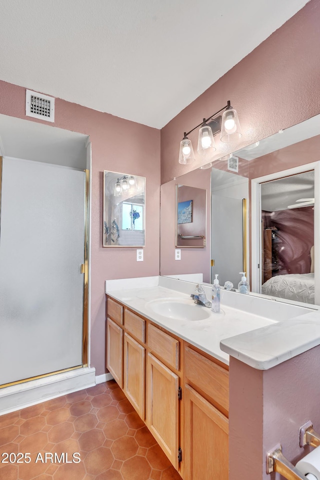 bathroom featuring a shower with door, vanity, and tile patterned floors