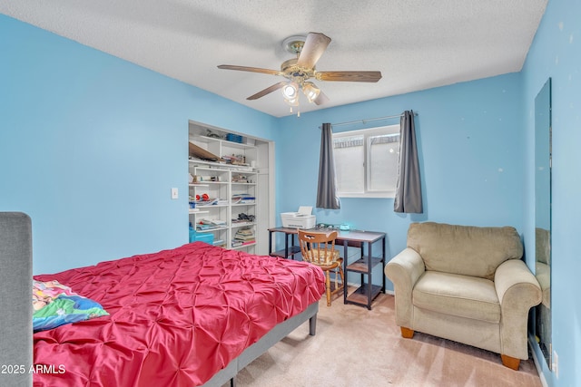 carpeted bedroom with ceiling fan and a textured ceiling