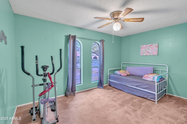 carpeted bedroom with ceiling fan and a textured ceiling