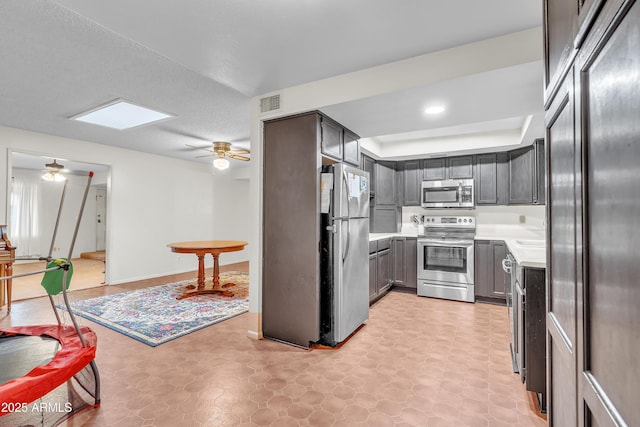 kitchen featuring ceiling fan, stainless steel appliances, and a skylight