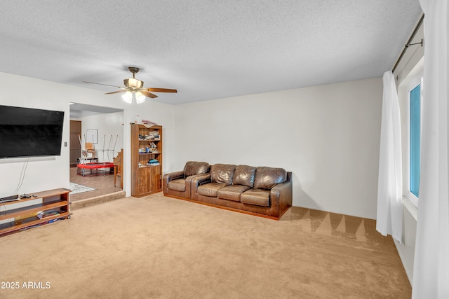 living room with ceiling fan, light colored carpet, and a textured ceiling