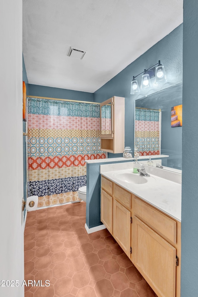 bathroom featuring vanity, curtained shower, and toilet