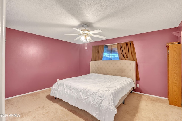 bedroom featuring ceiling fan, carpet floors, and a textured ceiling