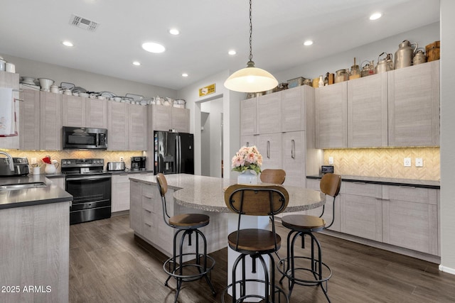 10359 E Los Lagos Vista Ave, Mesa, AZ 85209 - kitchen with black appliances, a kitchen breakfast bar, a center island, decorative backsplash, and recessed lighting