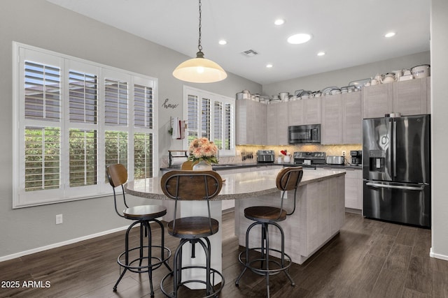 10359 E Los Lagos Vista Ave, Mesa, AZ 85209 - kitchen featuring appliances with stainless steel finishes, a breakfast bar, a kitchen island, dark wood-style flooring, and recessed lighting