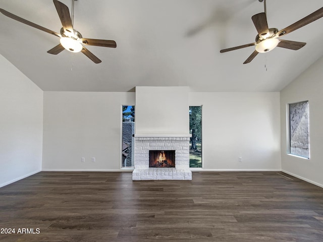 unfurnished living room featuring dark hardwood / wood-style floors, a brick fireplace, ceiling fan, and lofted ceiling