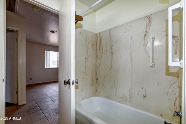 bathroom with tile patterned floors, shower / bathtub combination, and a textured ceiling