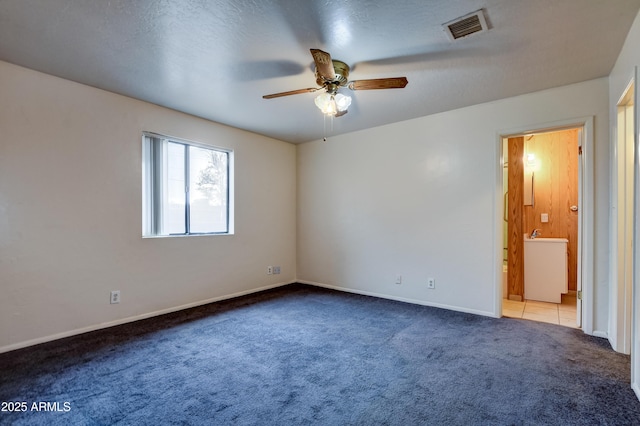 carpeted empty room featuring ceiling fan