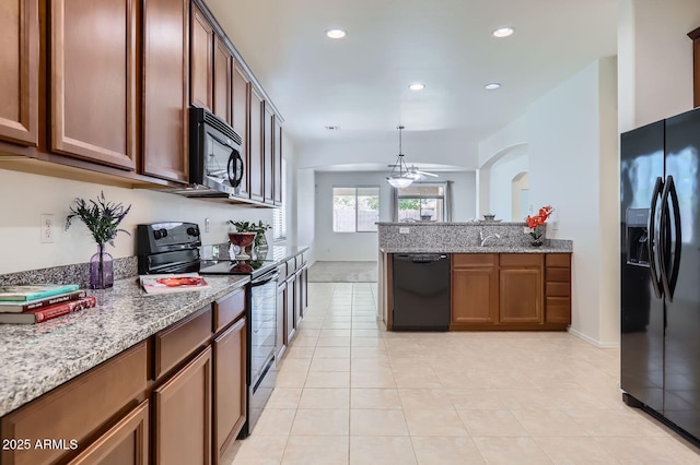 6815 W Carter Rd, Laveen, AZ 85339 - kitchen with black appliances, light stone counters, light tile patterned floors, recessed lighting, and a sink