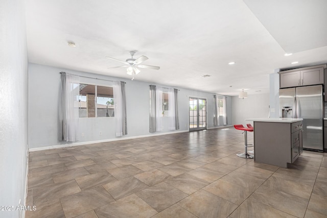 unfurnished living room featuring ceiling fan