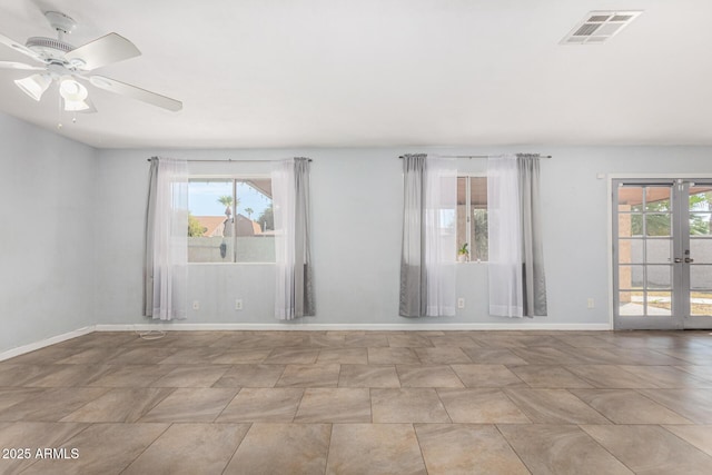 empty room with french doors, ceiling fan, and a healthy amount of sunlight