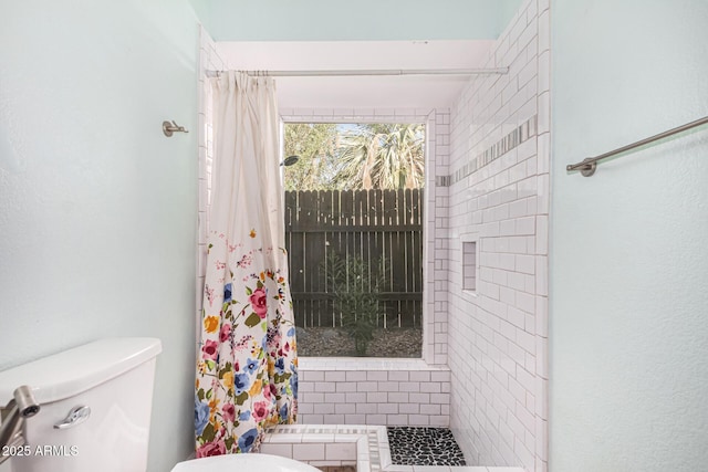 bathroom featuring a shower with curtain and toilet