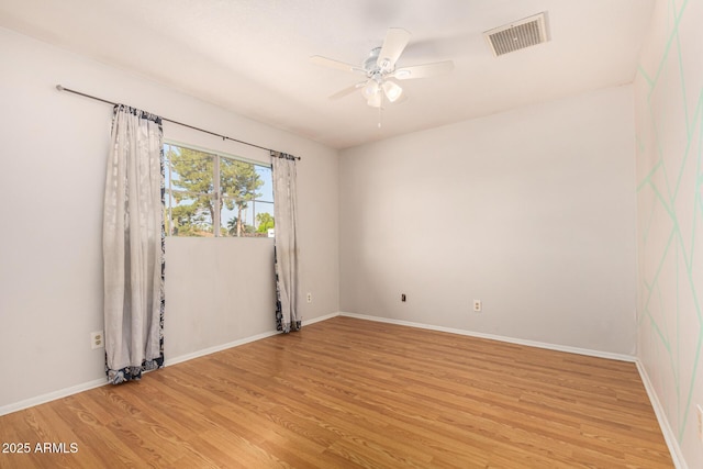 empty room with ceiling fan and light hardwood / wood-style floors