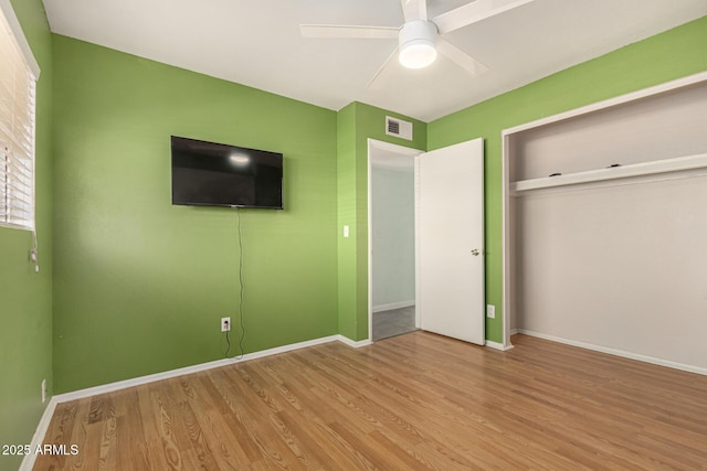 unfurnished bedroom with hardwood / wood-style flooring, a closet, and ceiling fan