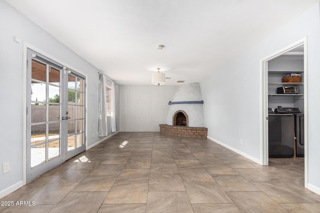 unfurnished living room with washing machine and clothes dryer and a brick fireplace