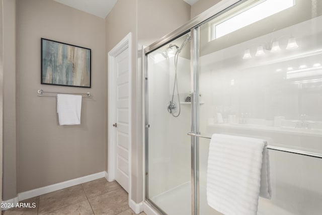 bathroom with tile patterned flooring and a shower with shower door