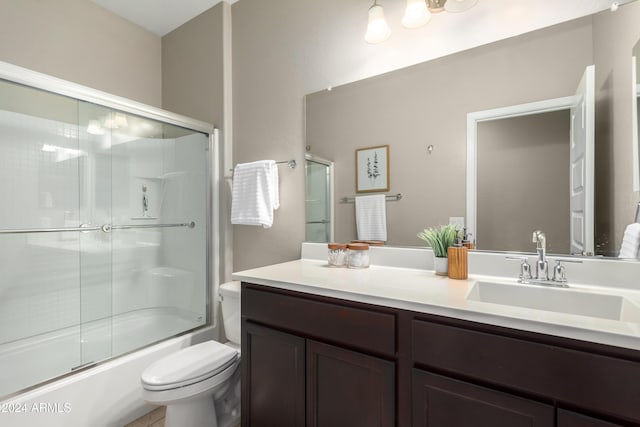 full bathroom with shower / bath combination with glass door, vanity, and toilet