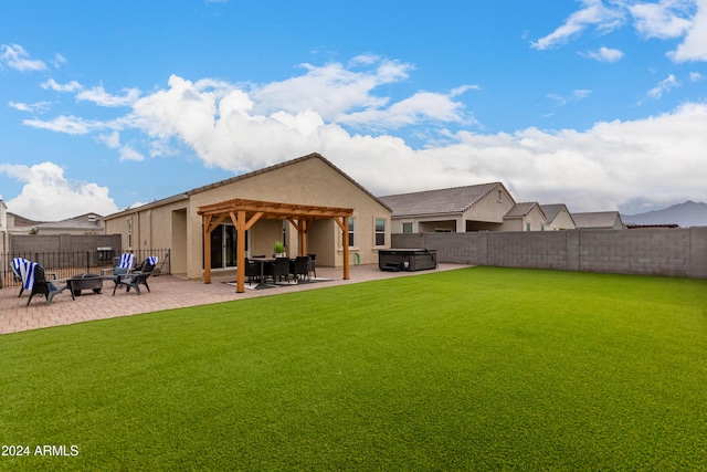 back of property featuring a patio, a hot tub, and a lawn