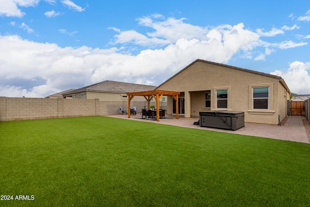 back of property with a patio, a pergola, a hot tub, and a lawn