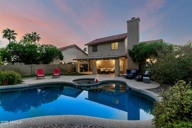15621 S 37th Way, Phoenix, AZ 85048 - pool at dusk with a fenced backyard, an outdoor living space, a patio, and a pool with connected hot tub