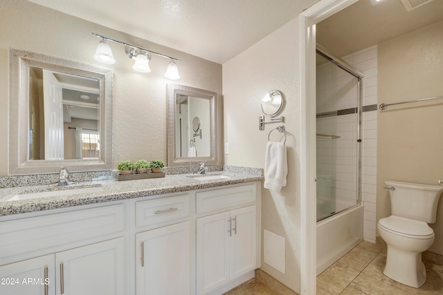 full bathroom featuring vanity, combined bath / shower with glass door, toilet, and tile patterned floors