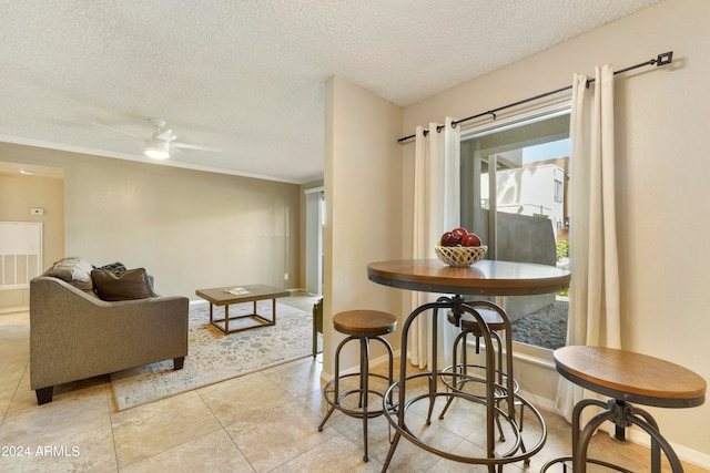 dining area with a textured ceiling and ceiling fan