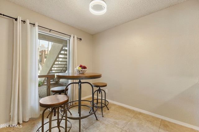 tiled dining room with a textured ceiling