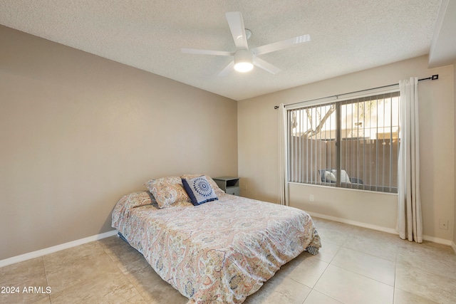 tiled bedroom with a textured ceiling and ceiling fan