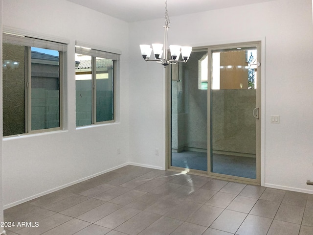 unfurnished room featuring tile patterned floors and an inviting chandelier