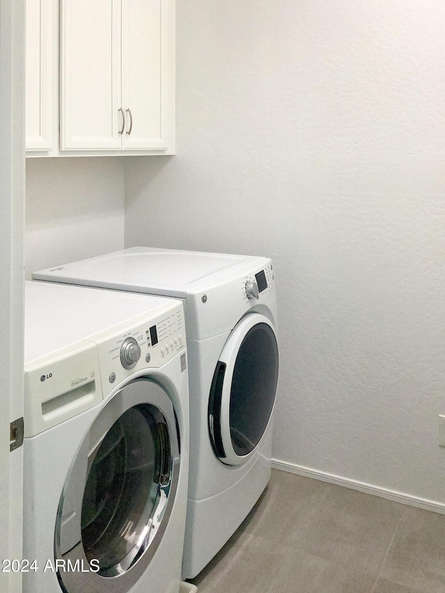 washroom with cabinets and washing machine and dryer