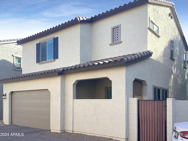 2550 N 149th Ave, Goodyear, AZ 85395 - view of front of house with an attached garage, stucco siding, a tiled roof, and a gate