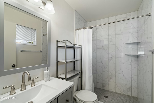 bathroom featuring toilet, a shower stall, and vanity