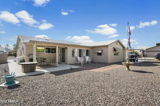 rear view of property with a patio area and stucco siding