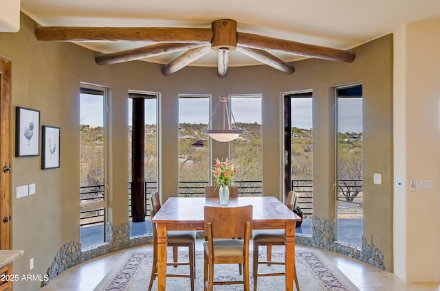 dining area with beamed ceiling and a ceiling fan