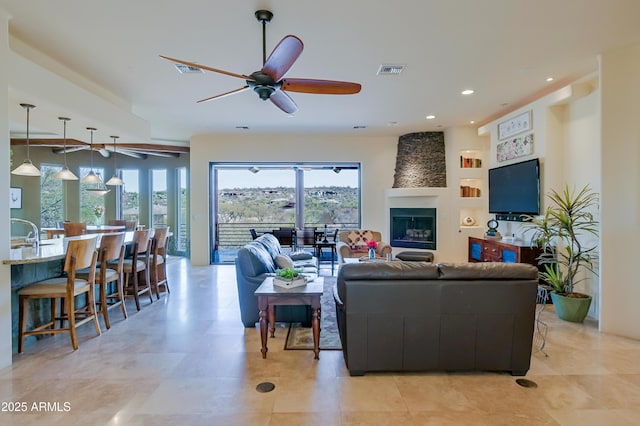 living area featuring recessed lighting, visible vents, a fireplace, and a ceiling fan