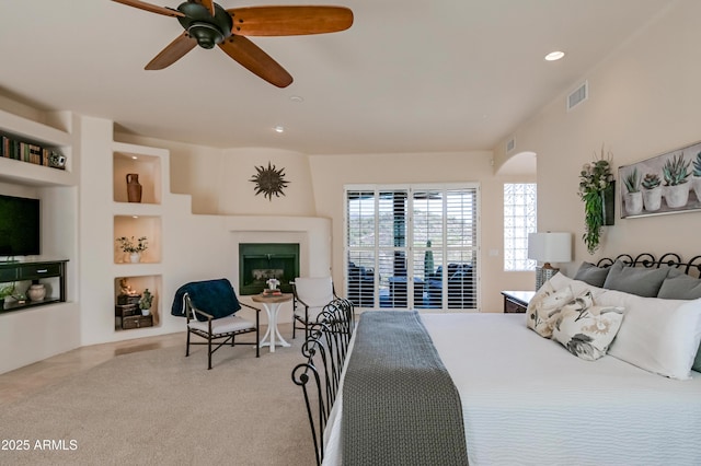 carpeted bedroom featuring visible vents, a ceiling fan, access to outside, a glass covered fireplace, and recessed lighting