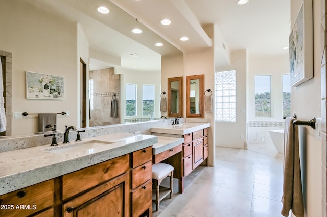 bathroom featuring recessed lighting, a freestanding tub, vanity, and tile patterned flooring