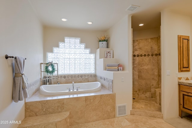 bathroom with visible vents, a bath, and a walk in shower